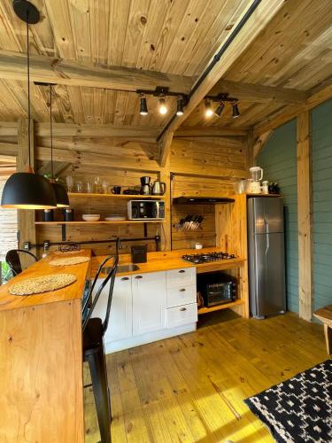 a kitchen with wooden walls and a wooden ceiling at Vila dos Cedros in Rio dos Cedros