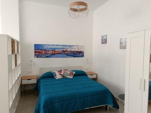 a bedroom with a blue bed and a painting on the wall at Urban loft in Forio d'Ischia