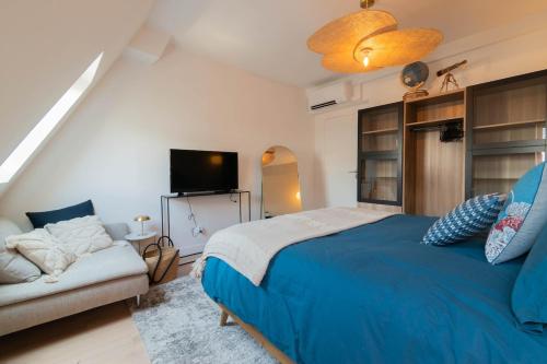 - une chambre avec un lit bleu et un canapé dans l'établissement 1 Min Opera - AC - Authentic Parisian Experience, à Paris