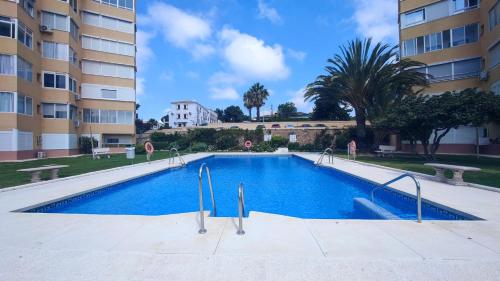 a swimming pool in front of a building at En Casa de Carlos perfect view in Mijas Costa