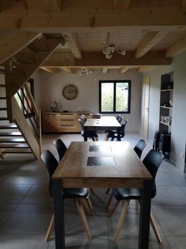 une salle à manger avec une table et des chaises en bois dans l'établissement Grand gîte des Marolais, à Mont-Saxonnex