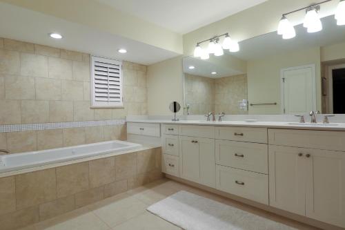 a bathroom with two sinks and a tub and a mirror at Pine Cove 204 in Sanibel