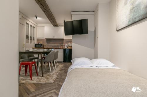 une chambre avec un lit et une table avec des chaises dans l'établissement MBA - Splendide appartement Proche Marais, à Paris