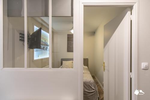 - un miroir dans une chambre avec un lit et une télévision dans l'établissement MBA - Splendide appartement Proche Marais, à Paris