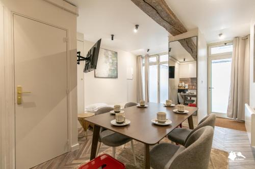 un salon avec une table et des chaises en bois dans l'établissement MBA - Splendide appartement Proche Marais, à Paris