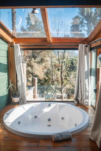 a bath tub in a room with a large window at Vila dos Cedros in Rio dos Cedros