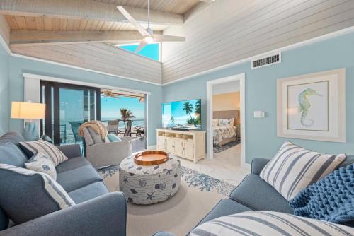 a living room with blue furniture and a bedroom at Pine Cove 403C in Sanibel