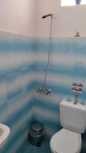 a blue tiled bathroom with a toilet and a sink at Myrtia Vacation Home in Karpathos Town