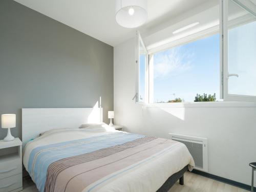 une chambre blanche avec un lit et une fenêtre dans l'établissement La Dune N 25 - Villa 3P7, à Sérignan