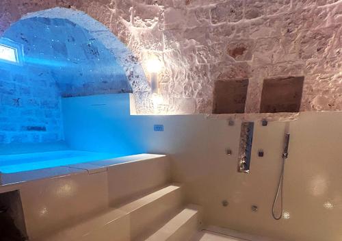 a bathroom with a bath tub in a stone wall at Luxury Suite & Spa Trullo Monte Farella in Putignano