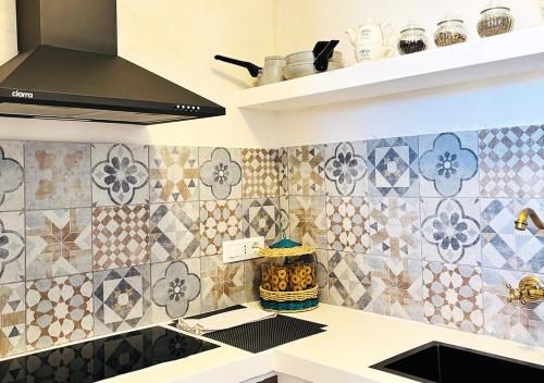 a kitchen with tiles on the wall at Luxury Suite & Spa Trullo Monte Farella in Putignano