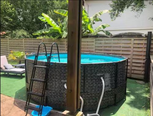 - une piscine avec une chaise à côté d'un poteau dans l'établissement Location Seignosse, à Seignosse