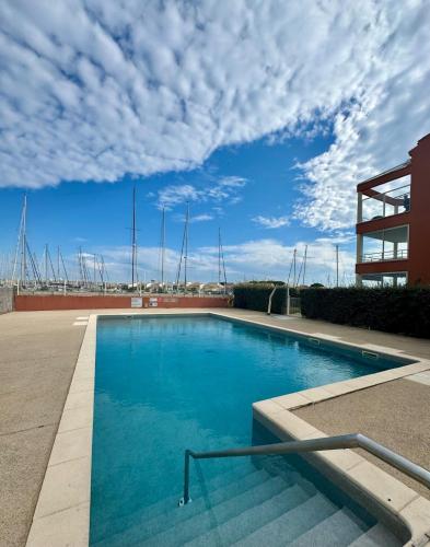 - une piscine avec vue sur un bâtiment dans l'établissement Appartement - Cap d'Agde Vue Port, au Cap d'Agde