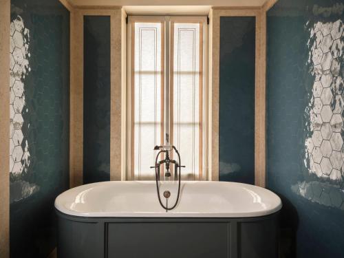 a bath tub in a bathroom with a window at Collegio alla Querce, Auberge Collection in Florence