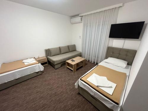 a hotel room with two beds and a couch at Motel Aura in Mostar