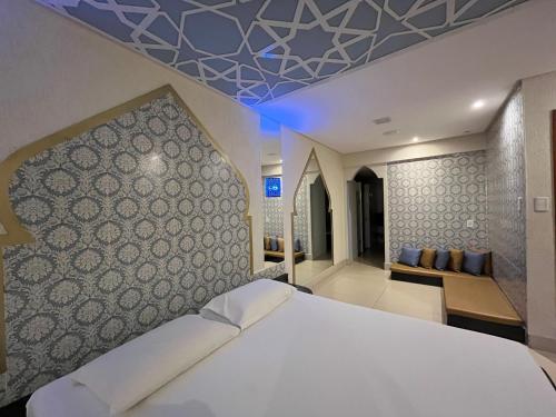 a bedroom with a large white bed and a couch at Drops Motel Goiânia in Goiânia