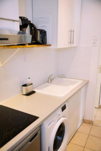 une cuisine avec une machine à laver et un évier dans l'établissement Hyper-centre Toulon T2 climatisé, à Toulon