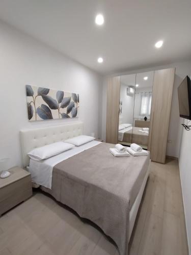 a bedroom with a large bed and a mirror at Manenti Holiday House in Noto
