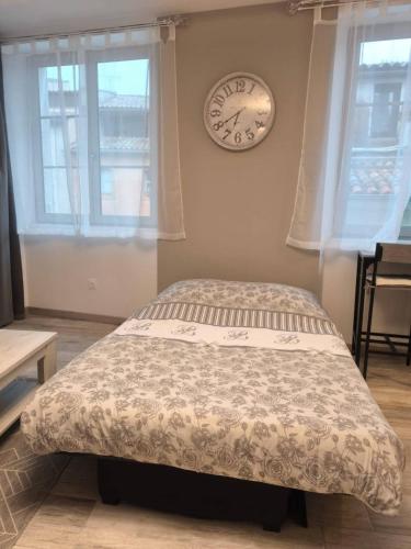 une chambre avec un lit et une horloge au mur dans l'établissement Escapade dans le Verdon classé 3 étoiles, à Riez