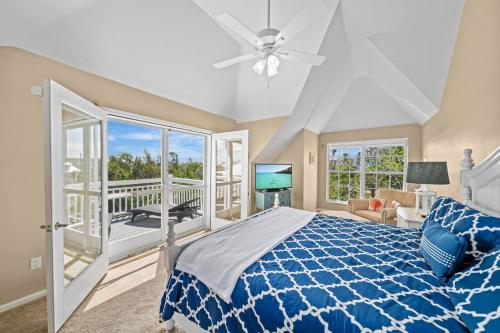 a bedroom with a blue bed and a balcony at Gone Coastal in Sanibel
