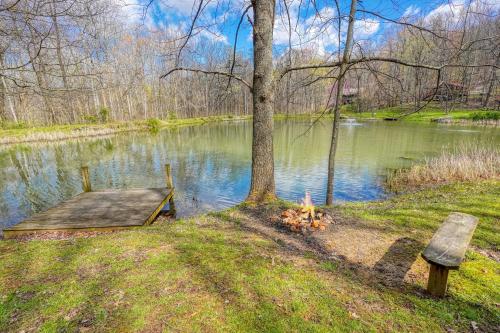 a bench next to a lake with a wooden dock at Wyandot Woods - Lake House in Laurelville