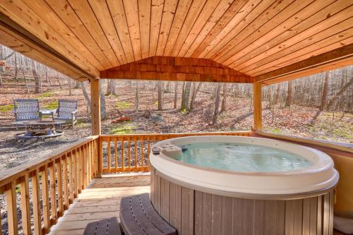 a hot tub on a deck with a wooden roof at Wyandot Woods - Lake House in Laurelville