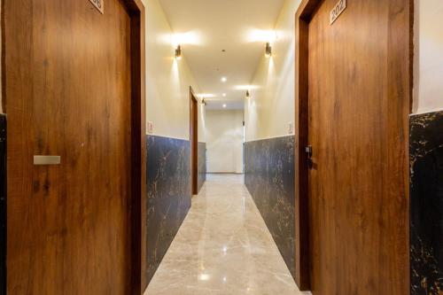 a hallway with wooden doors and a tile floor at ANTLERS HOTEL Near Borivali Railway Station in Jāmb