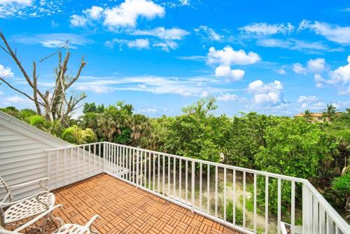 a balcony with chairs and trees in the background at Palm Whisper in Sanibel