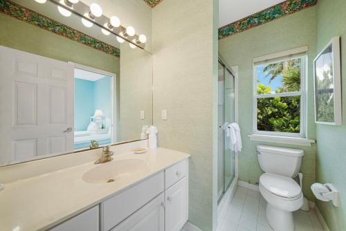 a bathroom with a sink and a toilet and a window at Palm Whisper in Sanibel