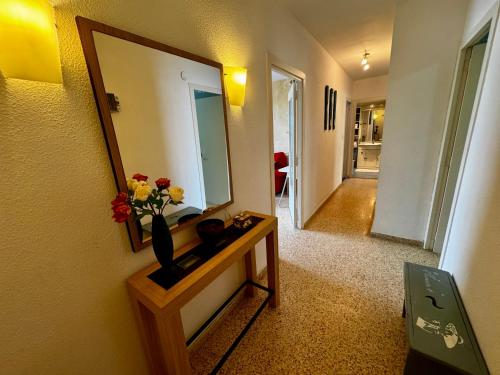 a room with a mirror and a vase with flowers on a table at Hermoso piso en la playa in Miramar