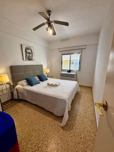 a bedroom with a bed and a ceiling fan at Hermoso piso en la playa in Miramar