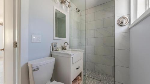 a white bathroom with a toilet and a sink at Little Palm Cottage in Sanibel
