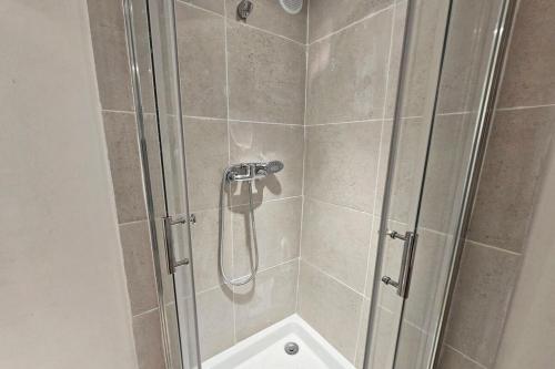 d'une douche avec une porte en verre et un pommeau de douche. dans l'établissement GregBnb - Appartement 1 chambre 39 m2 - Est, à Toulon