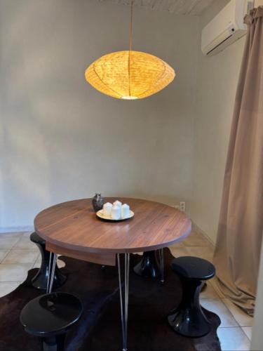 une table en bois avec deux chaises et une lampe dans l'établissement Les canisses, à Eygalières