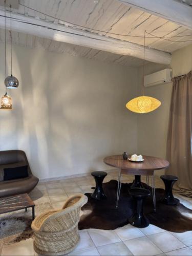 un salon avec une table et une chaise dans l'établissement Les canisses, à Eygalières