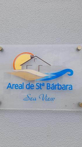 a white sign with a house on a beach at Areal de Santa Bárbara Sea View in Ribeira Grande