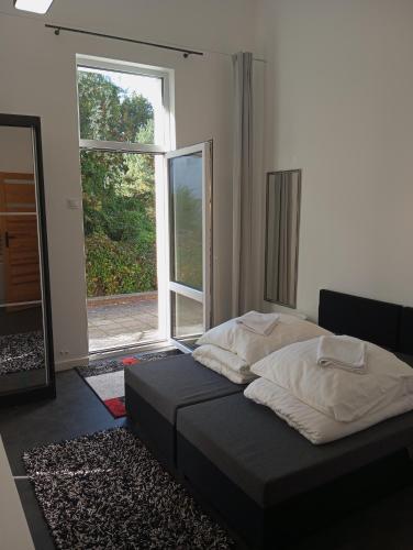 a bedroom with a bed and a large window at Mirabella 1 in Kołobrzeg