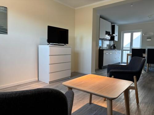 a living room with a tv and a table and chairs at 2013 FeWo Schauf Whg4 in Dahme
