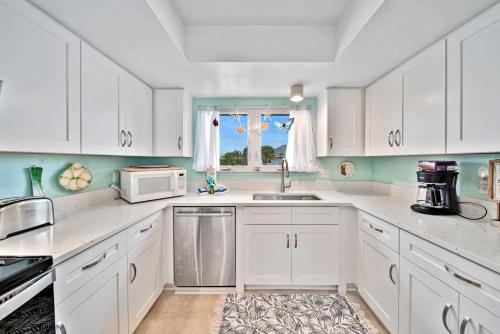 a kitchen with white cabinets and a sink and a window at The Turtle Nest in Sanibel