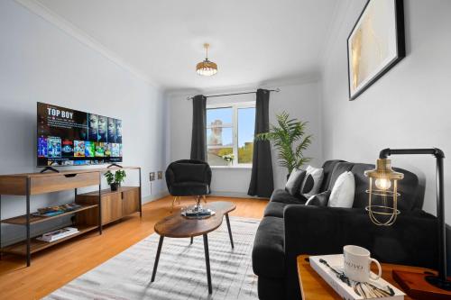 a living room with a black couch and a table at Modern Apartment - City Centre - Smart TV & Netflix 302Q in Birmingham