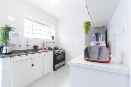 a white kitchen with a red blender on a counter at Casa aconchegante com 4 quartos na Vila Madalena in Sao Paulo