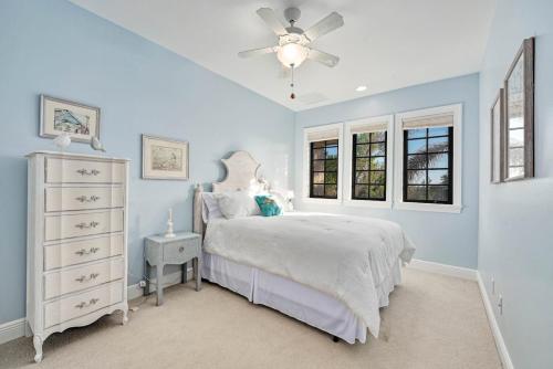 a bedroom with a white bed and a ceiling fan at Dockside Dream at Ding Darling in Sanibel