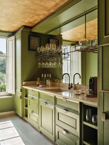 a kitchen with green walls and a large sink at Collegio alla Querce, Auberge Collection in Florence