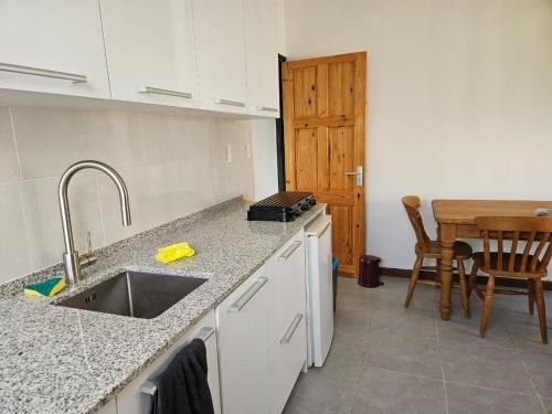 cocina con fregadero y mesa de madera en Jagtlust, en Meerzorg