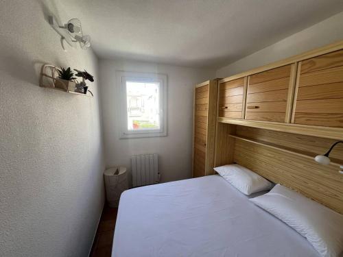 une chambre avec un lit blanc et une fenêtre dans l'établissement ALOA Joli 3 Pièces piscine proche plage Richelieu Cap d'Agde, au Cap d'Agde