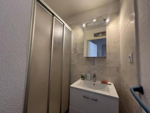 une salle de bain avec un lavabo et un miroir dans l'établissement ALOA Joli 3 Pièces piscine proche plage Richelieu Cap d'Agde, au Cap d'Agde