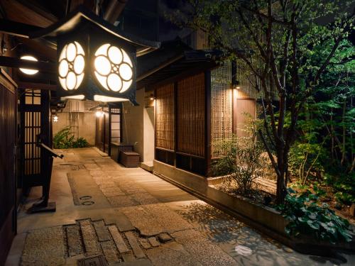 a building with a lit up walkway at night at Kyoto Machiya Fukune in Kyoto