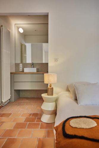 une chambre avec un lit et une salle de bain avec un lavabo dans l'établissement Ancienne bastide avec vue sur le Luberon, à Goult