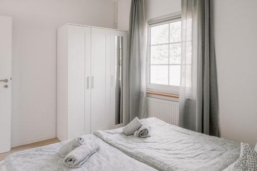 a bedroom with a bed with towels on it at Ferienhäuser Insel Usedom Haus Jojo 7 - Blick aufs Achterwasser! Whirlpool und Sauna in Lütow