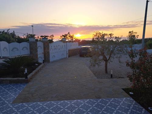 a sunset behind a white fence with a driveway at Paomà Sorrento in Agropoli